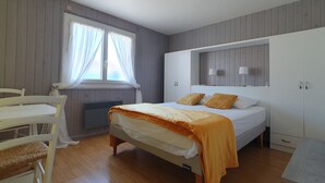 Une chambre à coucher avec un lit, un bureau et une chaise.