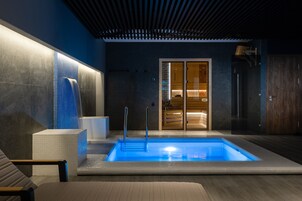 Una piscina techada, sillones reclinables de piscina