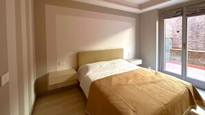 Un dormitorio con cama, ventana y puerta.