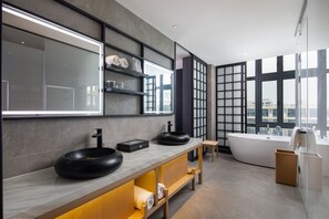A modern bathroom with a large mirror, two black sinks, a freestanding bathtub, and a view of the city through large windows. - GINCO Hotel Guangzhou Baiyun Airport (Guangzhou)