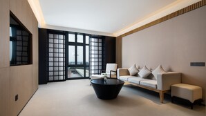 A modern living room with a sofa, a coffee table, and a large window with a view. - GINCO Hotel Guangzhou Baiyun Airport (Guangzhou)