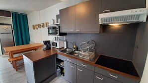 Ett kompakt kök med mikrovågsugn, brödrost och kaffebryggare.