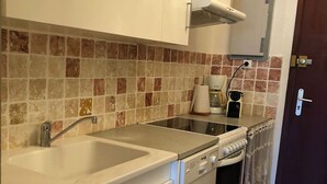Een keuken met een dubbele spoelbak, een fornuis en een koffiezetapparaat.