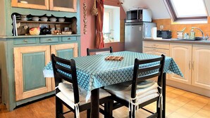 Una cocina acogedora con una mesa de comedor, sillas y un ventanal.