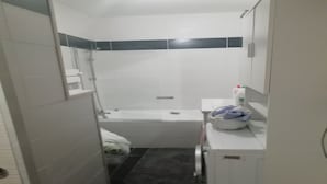 Une petite salle de bain avec une baignoire, des toilettes et un lavabo.