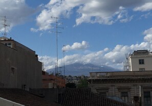 A cityscape with buildings, antennas, and a mountain in the background. - papali 289 (Catania)
