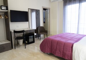 A bedroom with a bed, a desk, a chair, and a TV. - papali 289 (Catania)