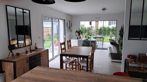 Eine moderne Küche mit Essbereich, großen Fenstern und Blick auf den Garten.