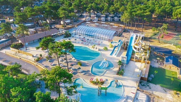 An aerial view of a resort with multiple swimming pools, a large covered area, and a water park. - Mobile home camping 5 stars (Vendays-Montalivet)