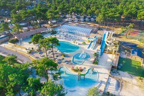 Ein Luftbild eines Resorts mit mehreren Schwimmbecken, einem großen überdachten Bereich und einem Wasserpark.