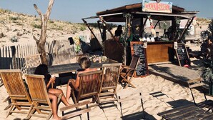 A beachside café with wooden furniture and a menu board. - Mobile home camping 5 stars (Vendays-Montalivet)