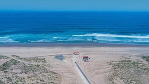An aerial view of a beach with a road leading to a building with a red roof. - Mobile home camping 5 stars (Vendays-Montalivet)