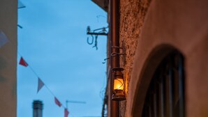 Eine enge Straße mit einem Laternenpfosten und einem Gebäude mit einer steinernen Fassade.