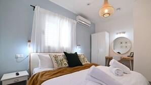 A well-lit hotel room with a bed, bedside table, and a mirror. - YalaRent Valley view complex In Merhavia with Private heated Pool (Emek Izrael)