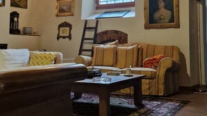 Une pièce rustique avec des poutres apparentes, un canapé, une table et une fenêtre.