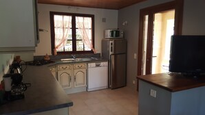 Una cucina compatta con forno a microonde, lavastoviglie e frigorifero.