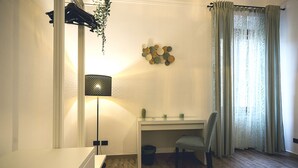 Ein Zimmer mit Schreibtisch, Stuhl und einer hängenden Pflanze.