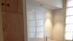 A modern bathroom with a wooden vanity, a white bathtub, and a sink. - Magnificent view, hyper center apartment (Tours)