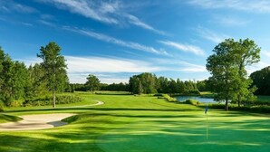 A golf course with a water hazard, sand bunkers, and a flagstick. - Jackson's Falls Country Inn (Prince Edward)