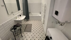 A bathroom with a white sink, mirror, and bathtub. - CITY CENTER 1, Fantastic apartment in the city center! (Budapest)