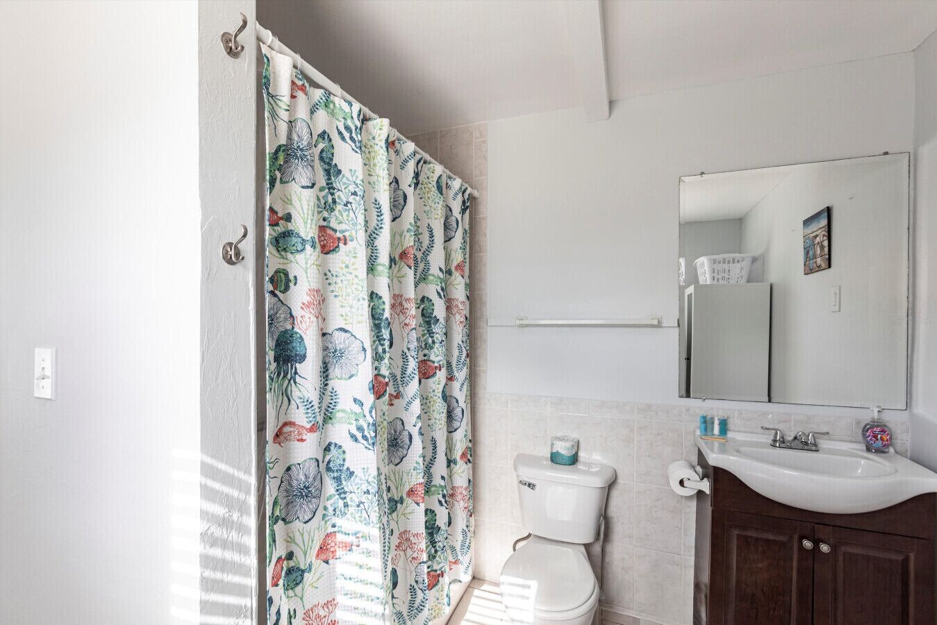 A bathroom with a toilet, sink, and mirror.
