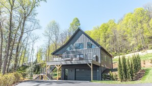A modern two-story house with a balcony, garage, and a driveway. - Luxury Mountain Escape (Hendersonville)