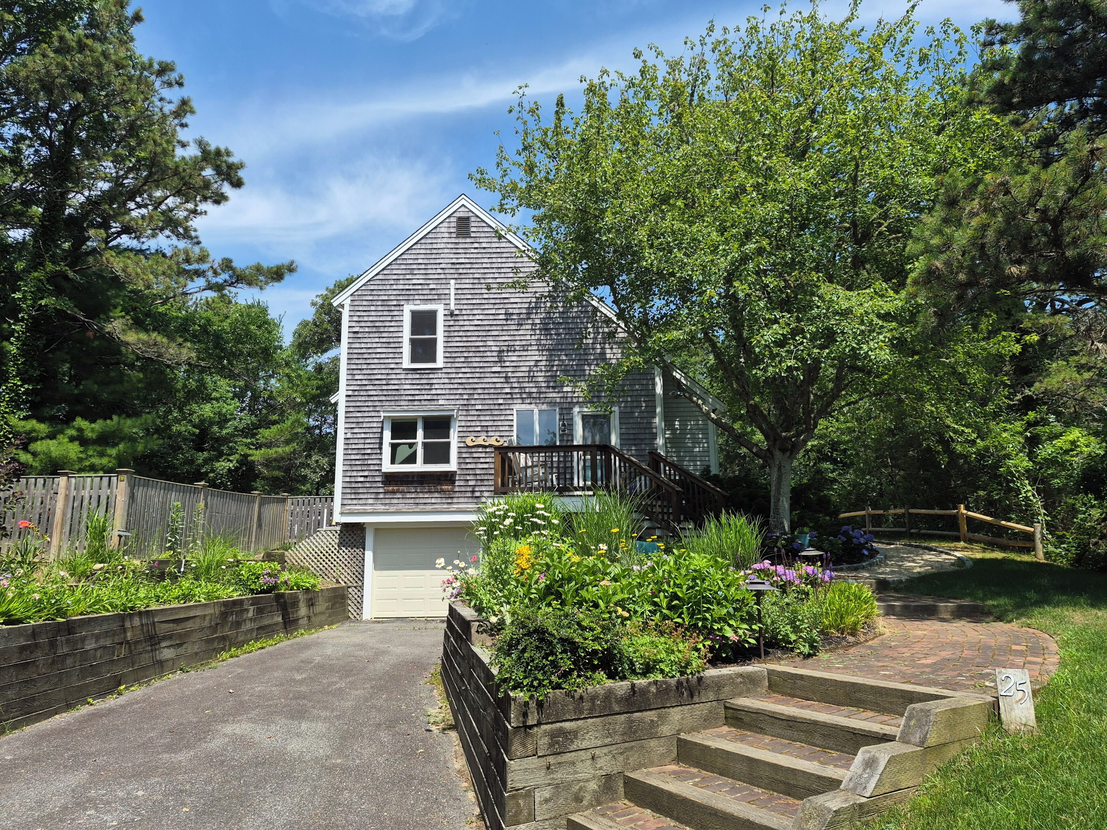 A two-story house with a front porch, a driveway, and a fenced yard.
