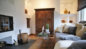 Ein gemütliches Wohnzimmer mit einer Couch, einem Couchtisch und einem großen Holzschrank.