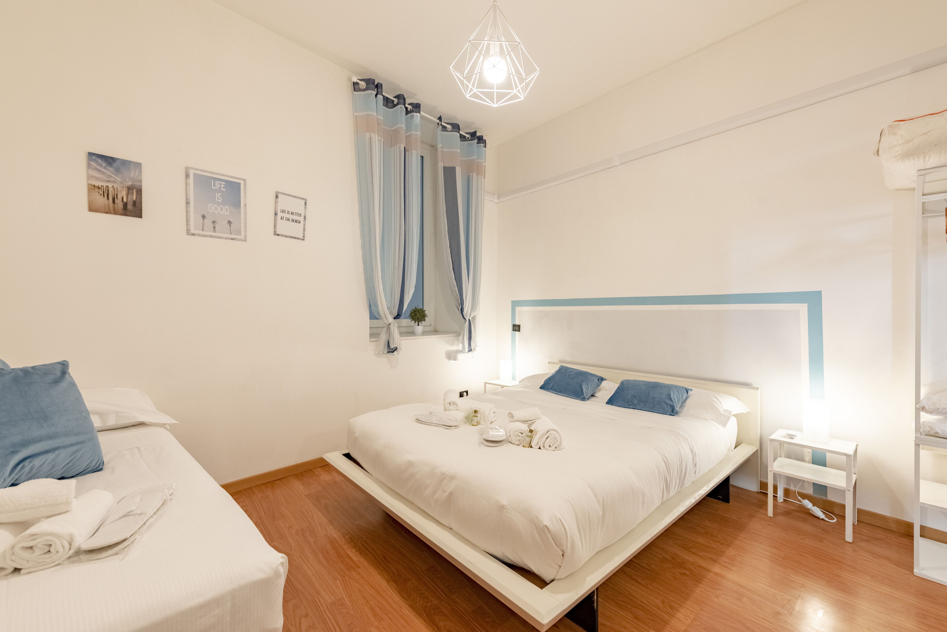Un dormitorio moderno con una cama, una mesita de noche y una pequeña silla blanca.