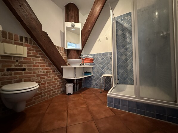 Un baño con inodoro, lavamanos y ducha.