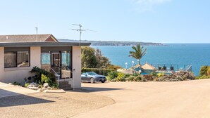 A modern house with a view of the sea, a swimming pool, and a parked car. - Breathtaking Clifftop Ocean Views in Eden - Unit 12 Bob and Zita’s escape (Eden)
