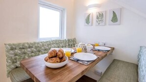 A breakfast setup with croissants, orange juice, and a coffee pot on a wooden table. - No 12. Southwold (Southwold)