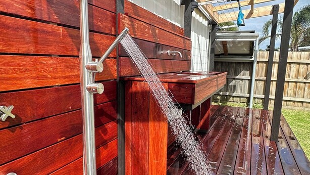 A wooden deck with a metal water feature. - Newly Renovated Hamptons-Style Beach House - Includes Linen & EV Charger! (Coronet Bay)