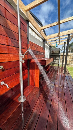 A wooden deck with a metal water feature.