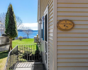 Uma casa com uma placa de madeira que diz 'B Chickadee Bay' e vista para um lago.