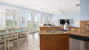 A spacious kitchen with granite countertops, wooden cabinets, and a dishwasher.
