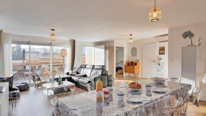 Un salon moderne avec une table à manger en verre, un canapé en cuir et une vue sur la ville.