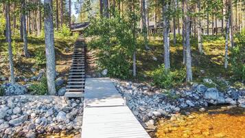 A wooden pathway leading to a cabin surrounded by trees.