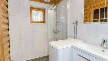 A bathroom with a shower, a window, and a sink.