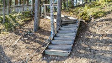 A wooden staircase in a forested area with a wooden fence and trees.