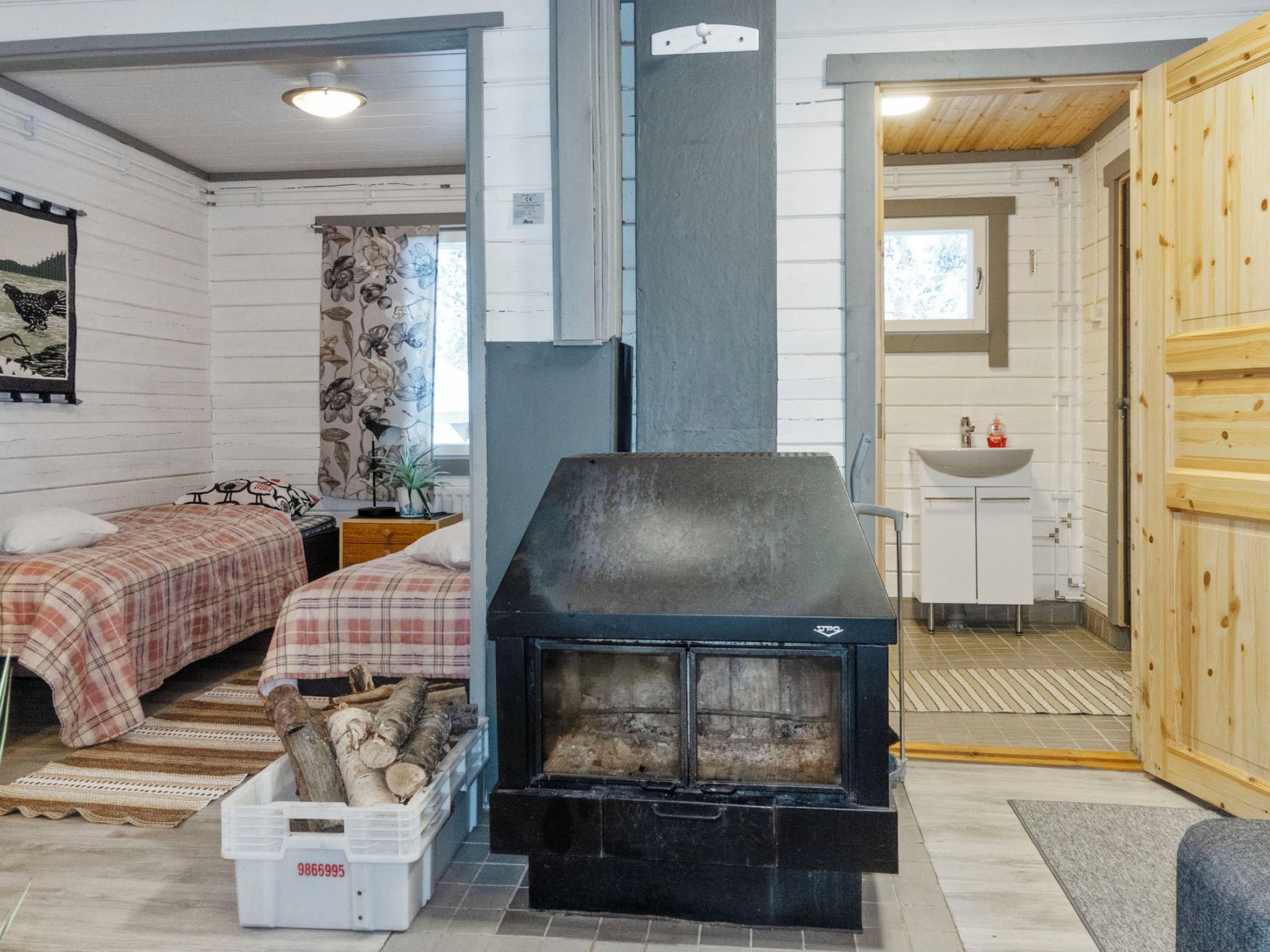 Ein gemütliches Zimmer mit Kamin, Bett, kleinem Tisch und Fenster.