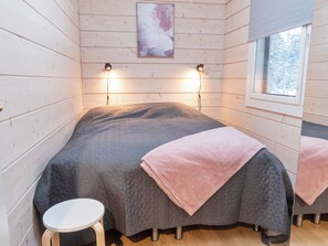 A cozy room with a bed, a small table, and a window.