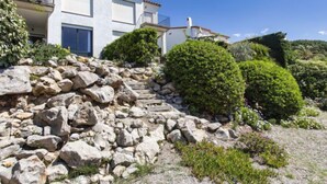 A modern two-story house with a stone retaining wall and well-maintained shrubbery. - Port del Rei I by Interhome (L'Escala)