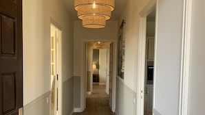 A hallway with wooden flooring, white walls, and a large woven light fixture. - Famous beaches 5 minutes from the house by car (Pianottoli-Caldarello)