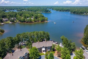 A residential area with houses near a large lake, boats docked, and a clear sky. - Great Views, Great Location, Near Ritz, No Stairs (Greensboro)