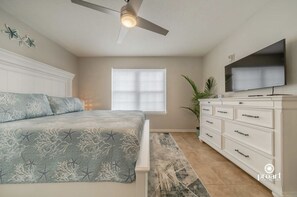 A bedroom with a bed, a ceiling fan, a TV, a window, and a dresser. - Blue Dolphin - 5 minutes from the beach and close to everything! (Destin)