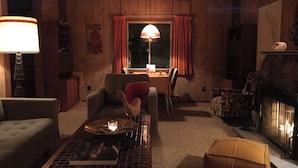 A cozy living room with a fireplace, a dining table, and comfortable seating.