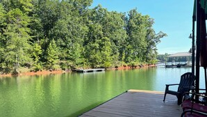 A wooden deck with a view of a lake surrounded by trees. - Lakefront cabin in quiet cove on Lake Hartwell (Hartwell)