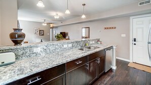 A kitchen with granite countertops, dark cabinetry, a refrigerator, and pendant lighting. - Walkable to Oakley Square-Newly Renovated-King Bed (Cincinnati)