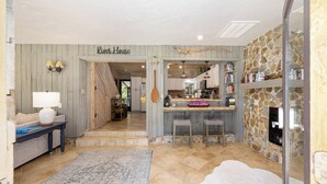 A cozy kitchen with a stone wall, wooden cabinets, and a bar area. - Beautiful secluded setting on the Rainbow River surrounded by state forest (Dunnellon)